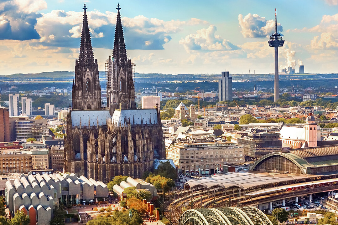 Blick über Köln mit Kölner Dom, Hohenzollernbrücke, Hauptbahnhof und Fernsehturm; Motiv zur Eventübersicht von BARMER Durchblickt.