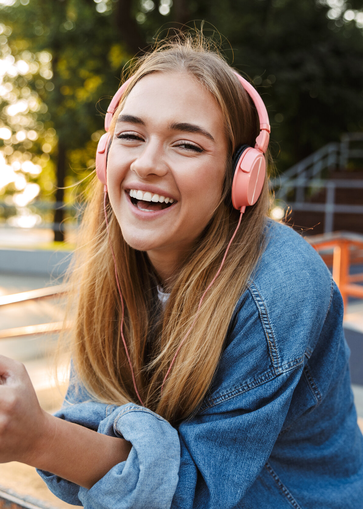 Jugendliche hört Podcast über digitale Gesundheit mit Kopfhörern im Park