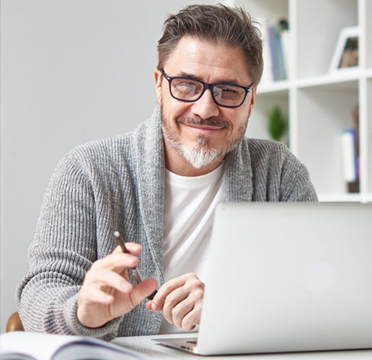 Mann sitzt vor Laptop