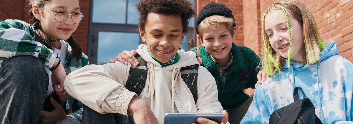 Gruppe Jugendlicher sieht etwas auf Smartphone an