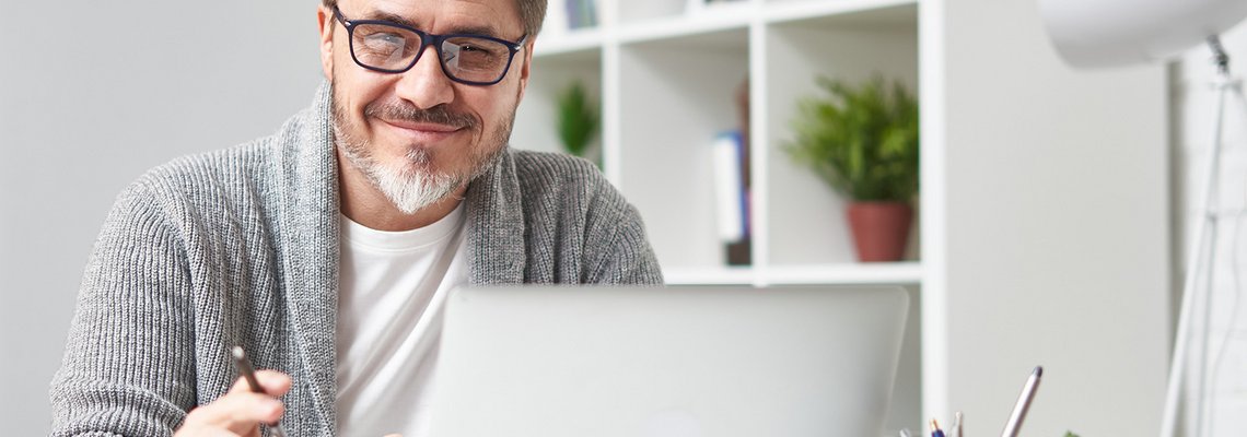 Mann sitzt vor Laptop