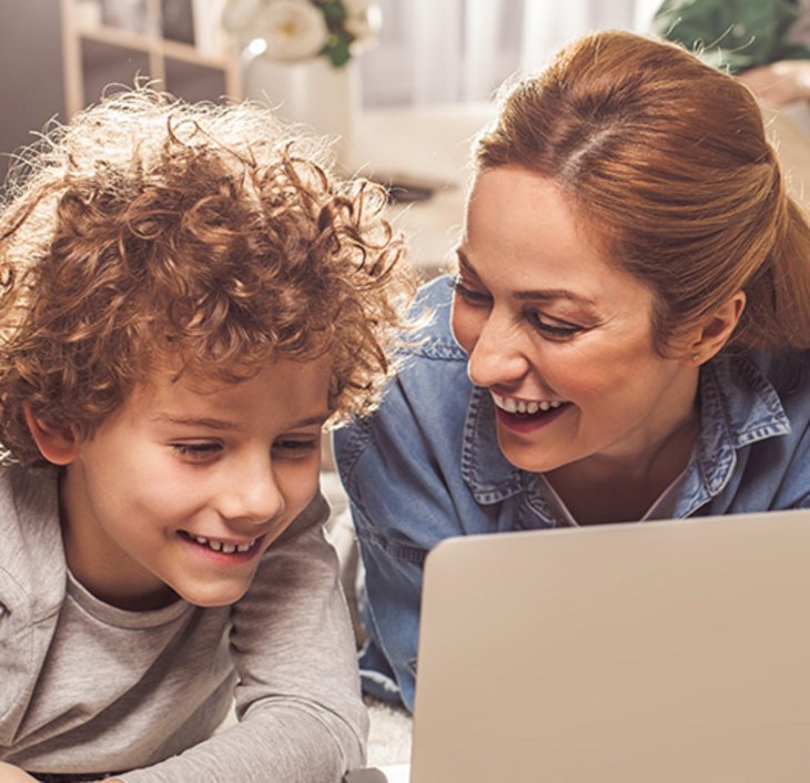 Frau und Junge sehen etwas auf dem Laptop an