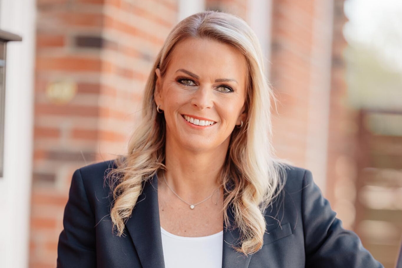 orträt von Silke Müller, Gastautorin bei BARMER Durchblickt, mit langen blonden Haaren und dunklem Blazer vor hellem Hintergrund.