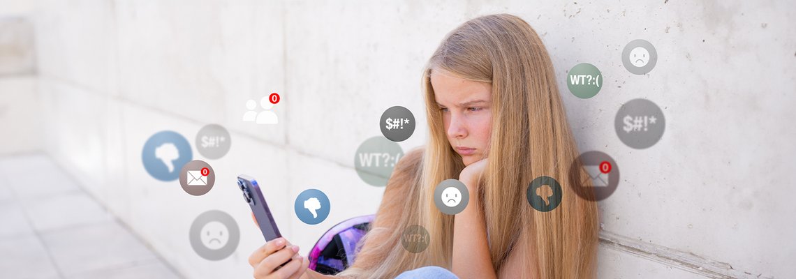 Mädchen blickt unglücklich auf Smartphone