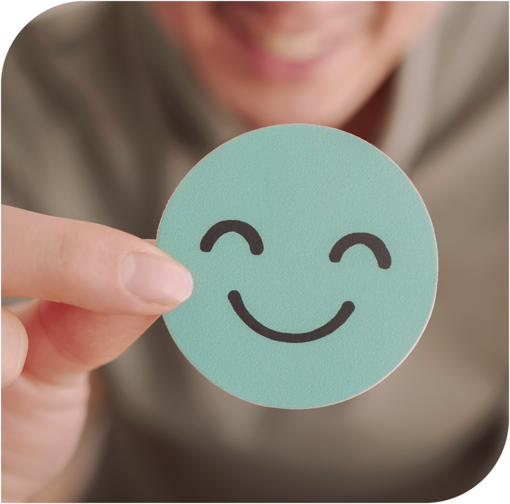 Person hält lächelnden Smiley
