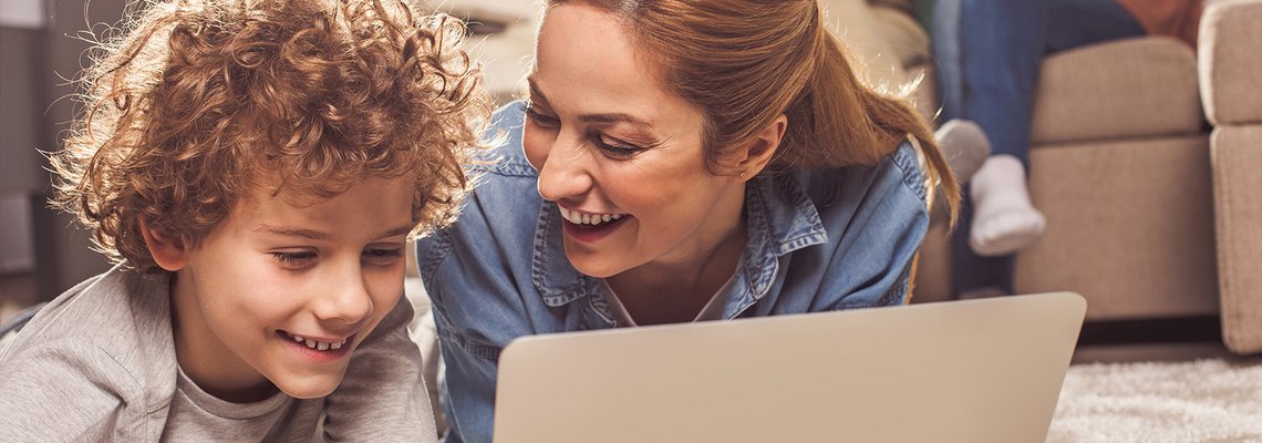 Frau und Junge sehen etwas auf dem Laptop an