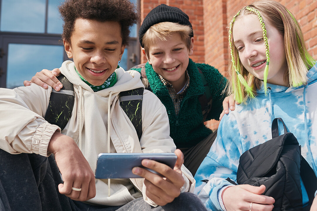 Gruppe Jugendlicher sieht etwas auf Smartphone an
