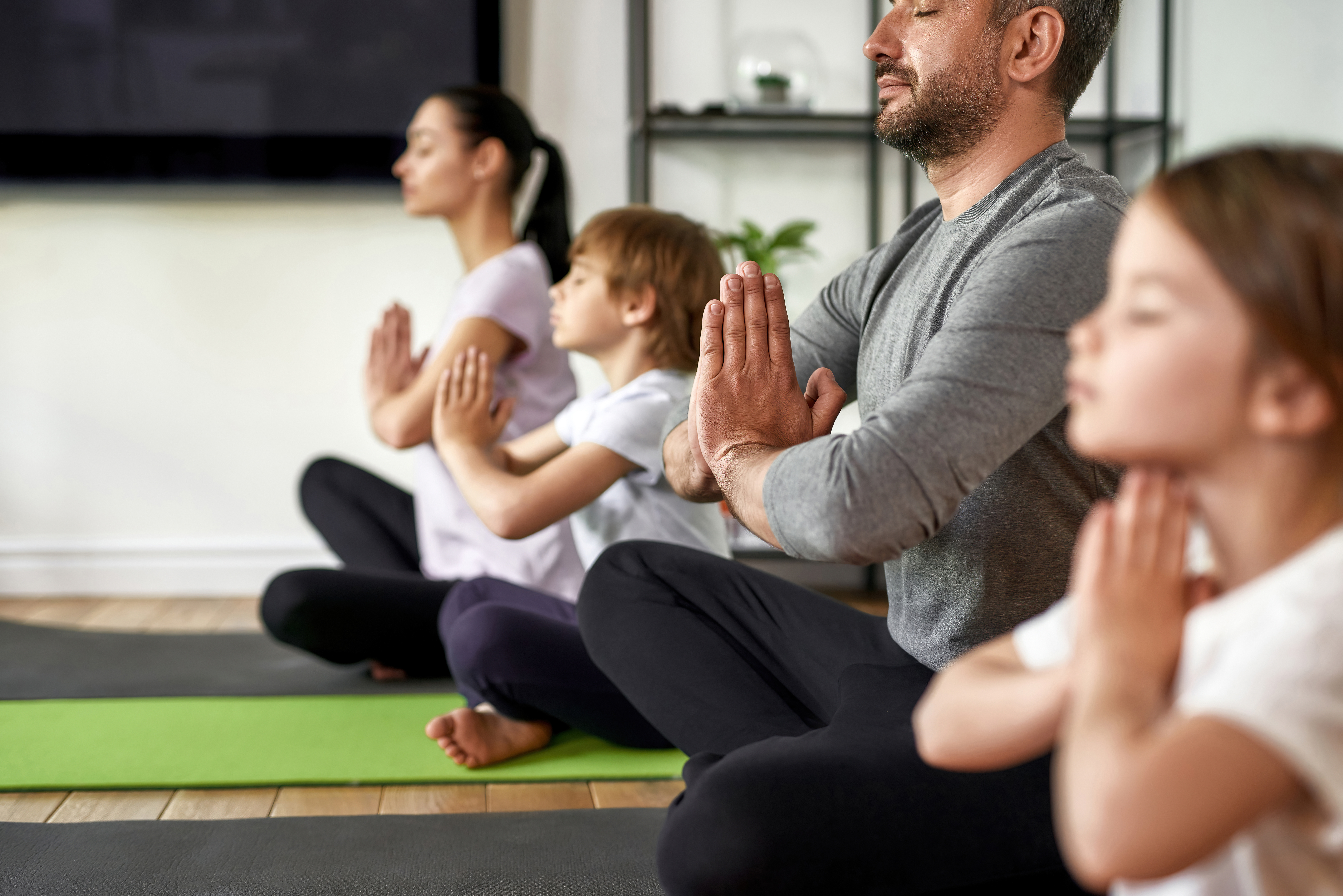Erwachsene und Kinder meditieren