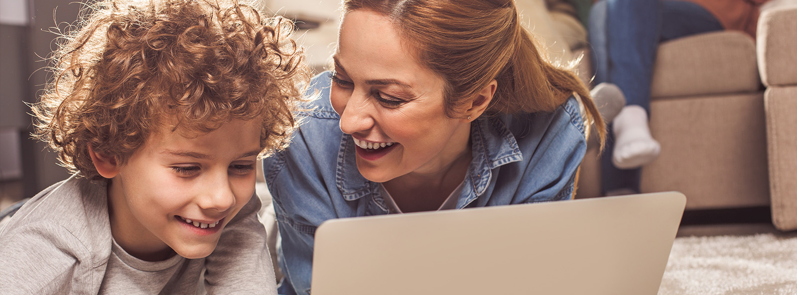 Frau und Junge sehen etwas auf dem Laptop an