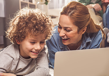 Frau und Junge sehen etwas auf dem Laptop an