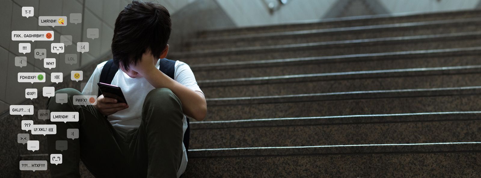 Junge mit Smartphone bekommt gemeine Nachrichten