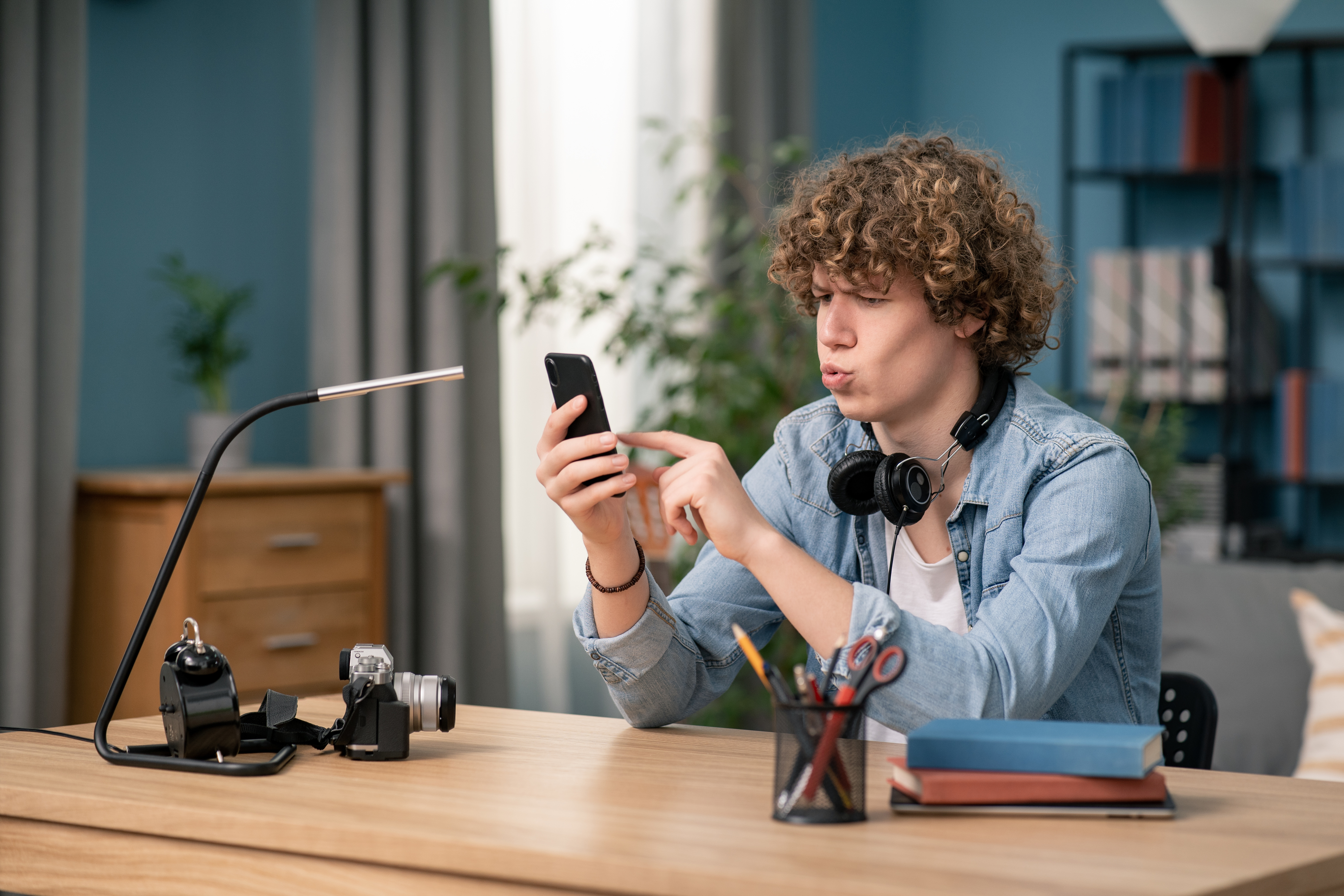 Teenager schaut ungläubig auf sein Smartphone