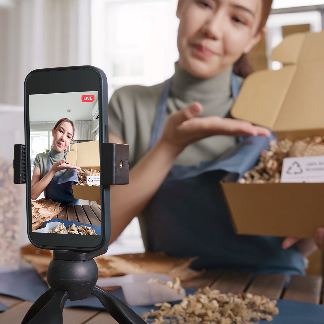 Mädchen präsentiert vor der Smartphone-Kamera einen offenen Karton mit umweltfreundlicher Verpackung. DGK_Artikel-16_Learning-to-recognise-advertising.jpg
