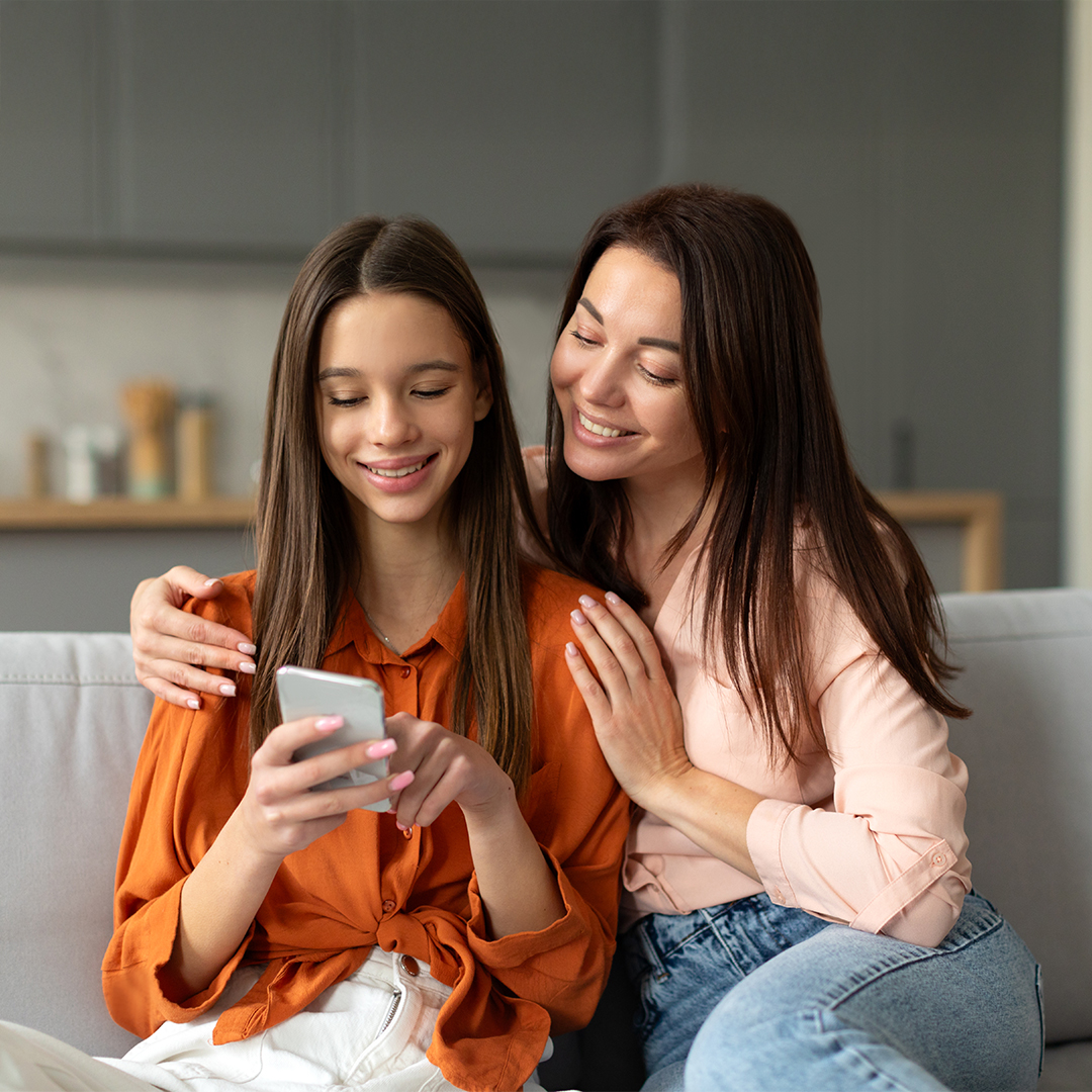 EIne mutter schaut ihrer Tochter über die Schulter die ihr etwas auf dem Smartphone bei Discord zeigt. 20260910_DGK_Q4_Artikel_NEW-Discord.jpg