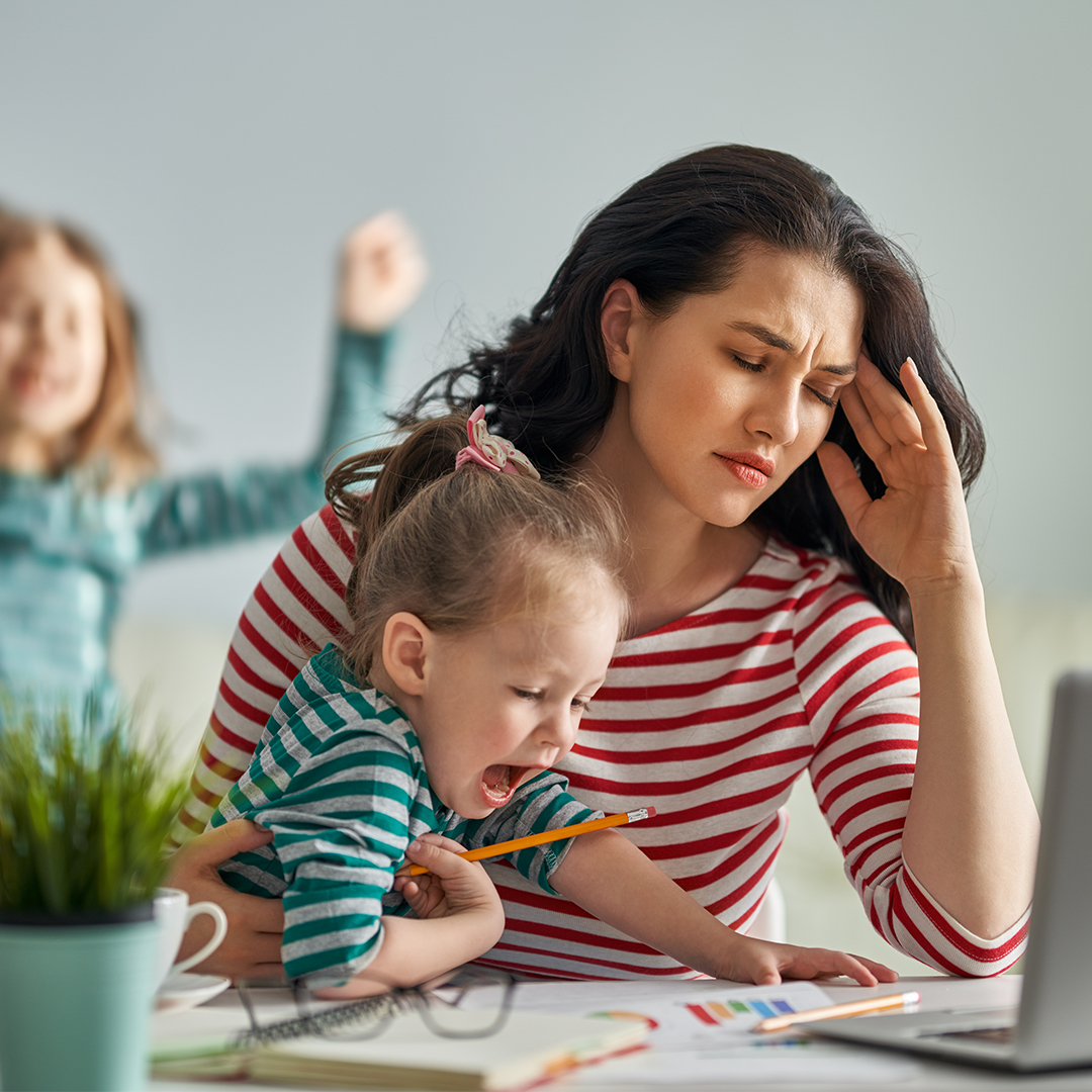 Gestresste Frau mit Kind auf dem Schoß sitzt vor Laptop DGK_Blog_07__23.12.01-header.jpg