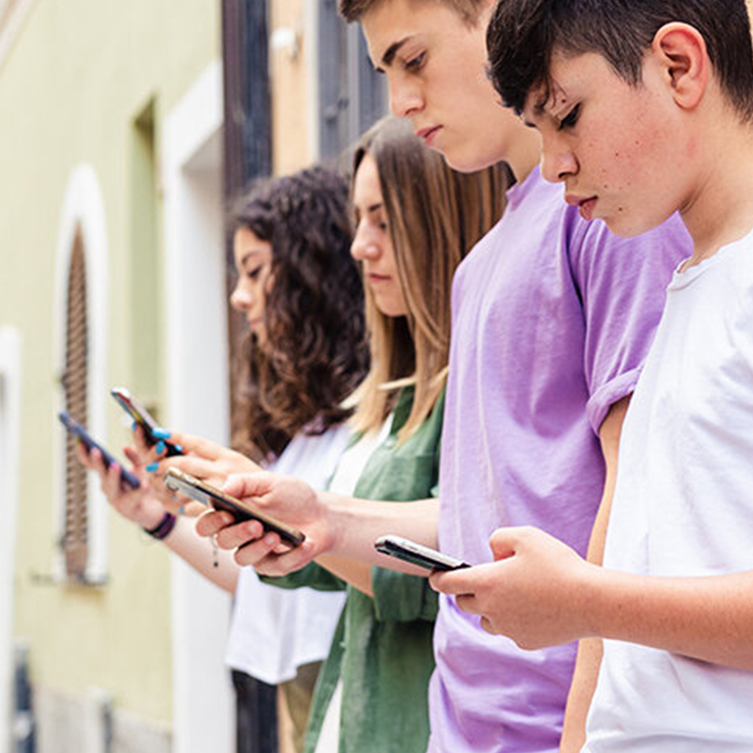 Vier Jugendliche lehnen mit Smartphones an Hauswand DGK_Schueler_und_Schuelerinnen_Social-Media-_-Mental-Health-header.jpg